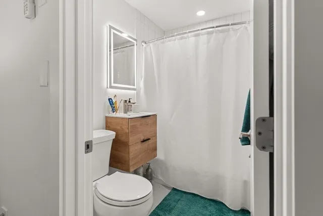 a white toilet sitting next to a bathroom sink