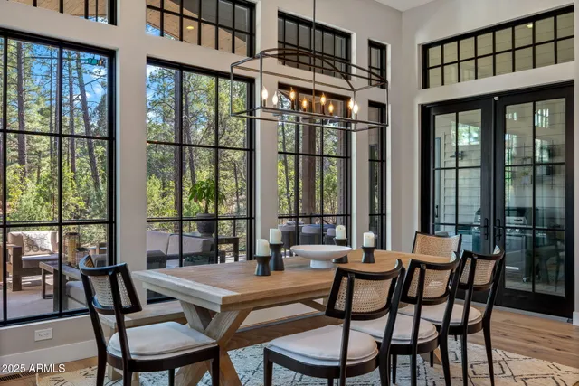 a dining room with furniture a chandelier and wooden floor