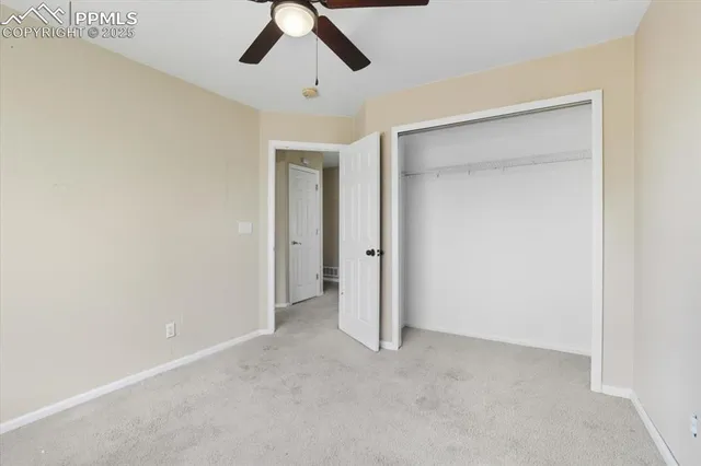 an empty room with chandelier fan