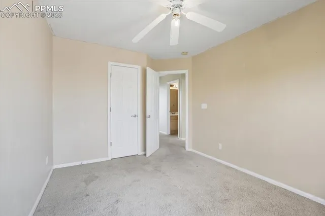 an empty room with a fan and a fan