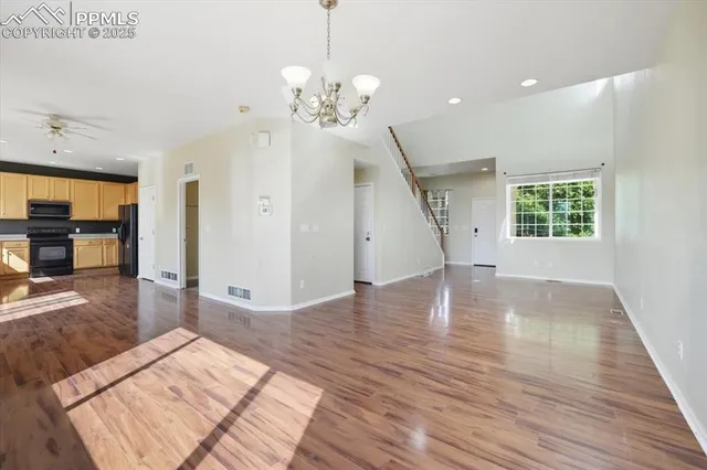 a view of a livingroom with wooden floor and staircase