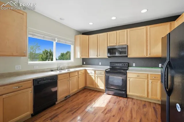 a kitchen with granite countertop wooden floors and stainless steel appliances
