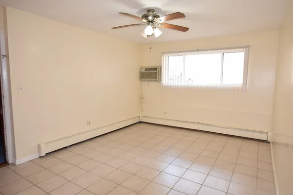 an empty room with windows and fan