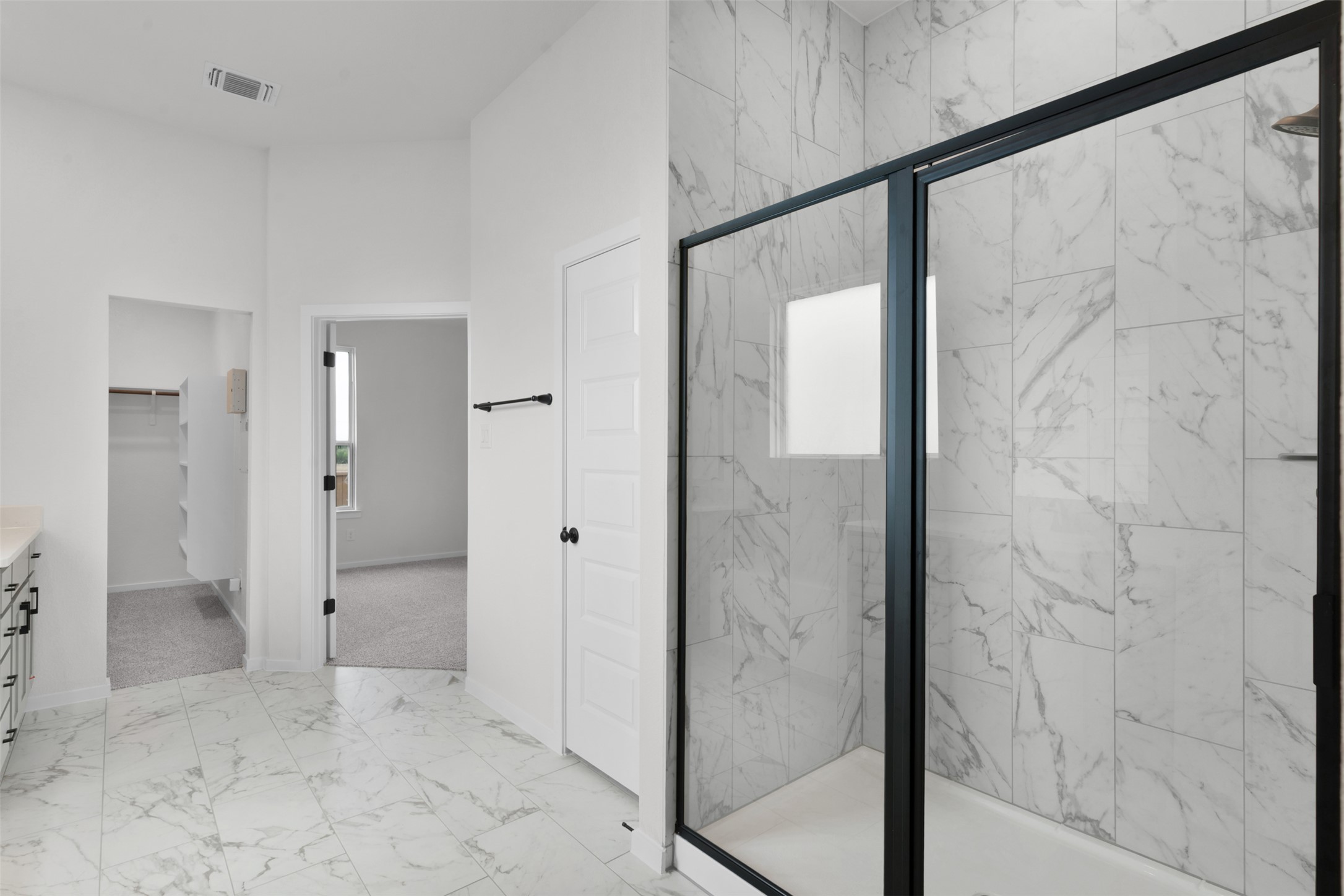 405 Raleigh Drive Georgetown, TX 78633 - Photo 12 of 27 Bathroom with light marble finish floors, vanity, a walk in closet, a marble finish shower, and plenty of natural light