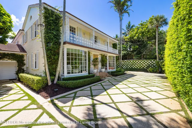 a view of a house with a large window and flower plants