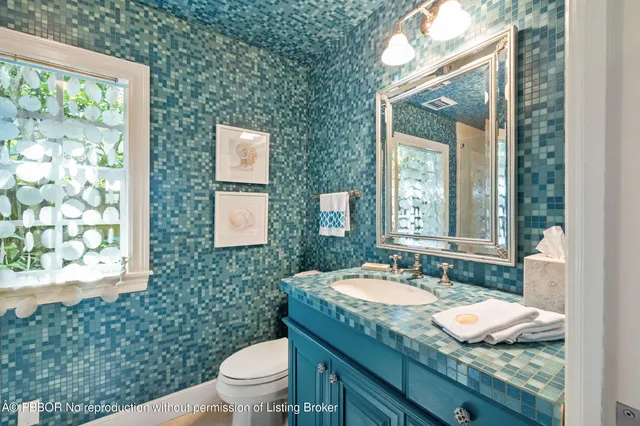 a bathroom with a granite countertop sink a toilet and a mirror