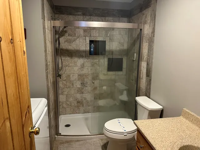 a bathroom with a toilet and a shower