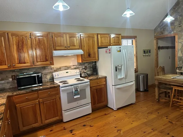 a kitchen with wooden cabinets and white appliances