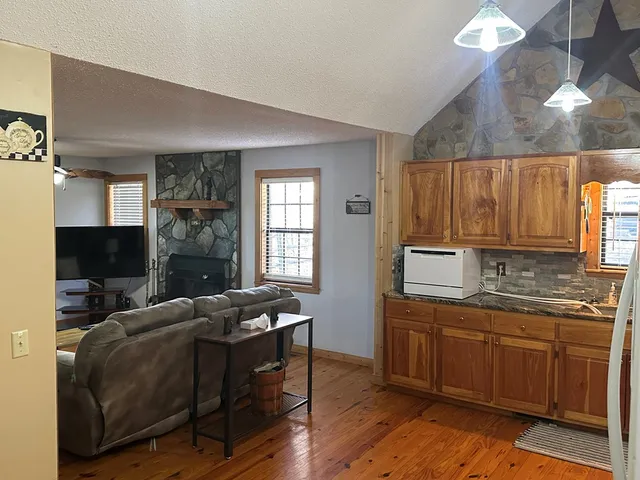 a kitchen with stainless steel appliances granite countertop a sink dishwasher stove and wooden floor