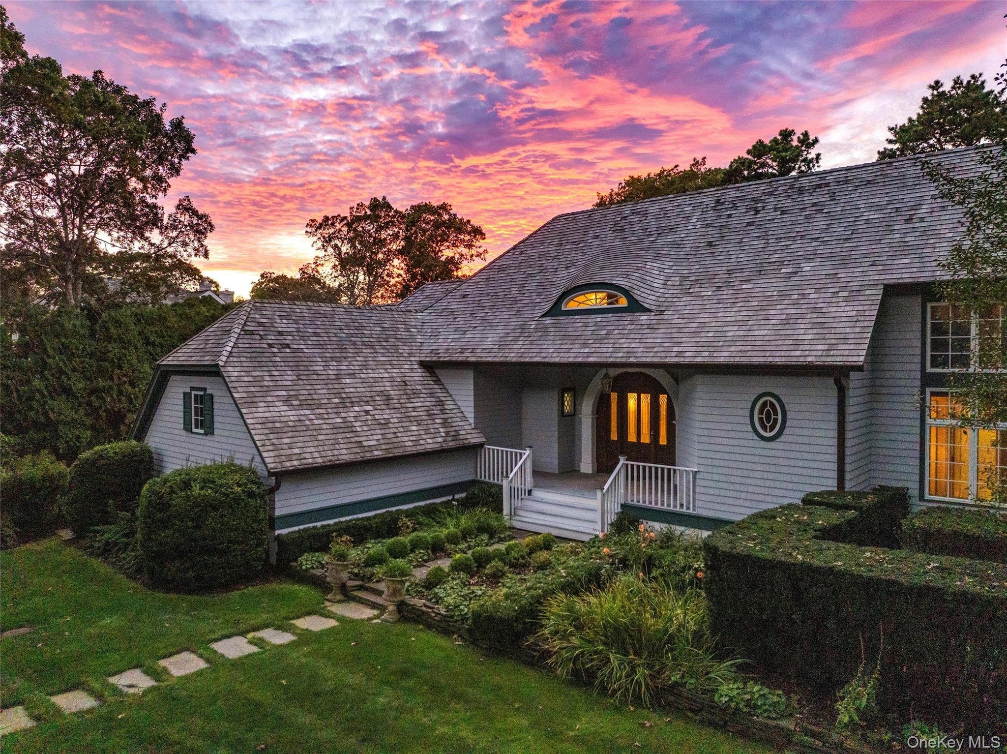 View of front of property with covered porch and a yard