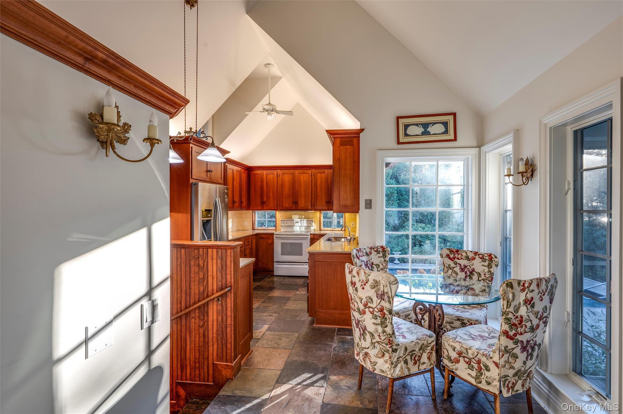 8 Fish Creek Lane Remsenburg, NY 11960 - Photo 15 of 35 Dining area with high vaulted ceiling, ceiling fan, and stone tile floors