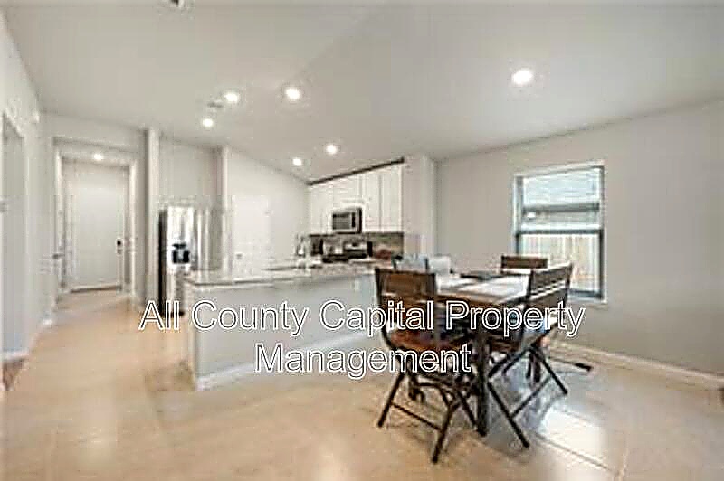 12313 Caldera Way Manor, TX 78653 - Photo 2 of 5 Open-concept kitchen and dining area featuring light-toned flooring, recessed lighting, and a kitchen island with a light-colored countertop