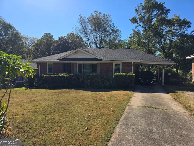 a front view of a house with yard plants and trees
