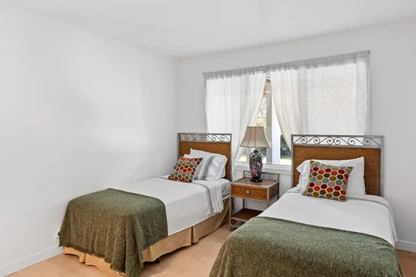 a bedroom with two beds and lamp