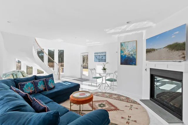 a living room with furniture a fireplace and a large window