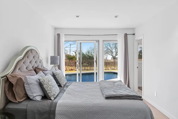 a bedroom with bed and a large window