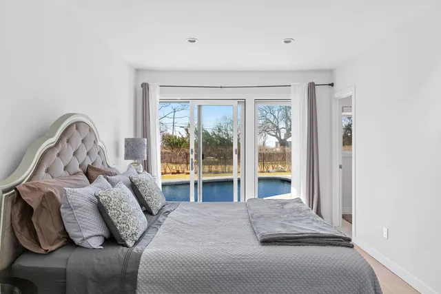 a bedroom with bed and a large window