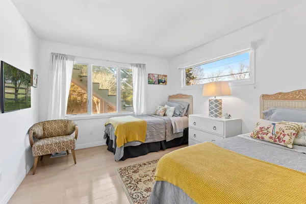 a bedroom with two beds and a large window
