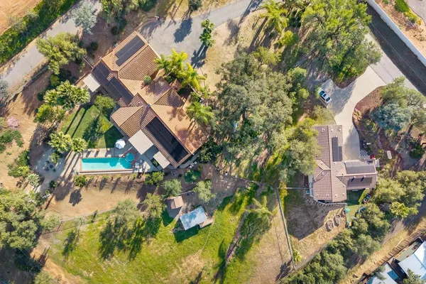an aerial view of a house with a garden and lake view