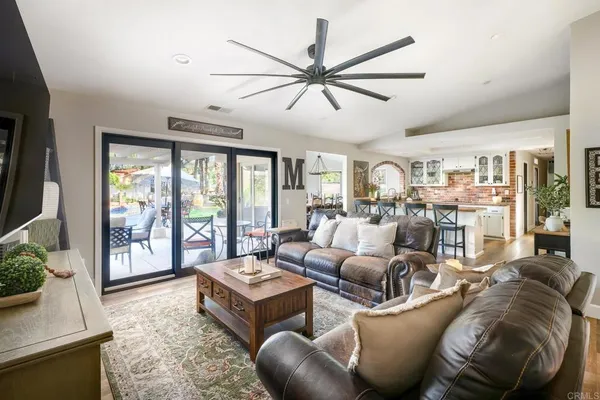 a living room with furniture a flat screen tv and a large window
