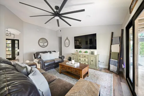 a kitchen with stainless steel appliances granite countertop a refrigerator a stove top oven a sink dishwasher and white cabinets with wooden floor