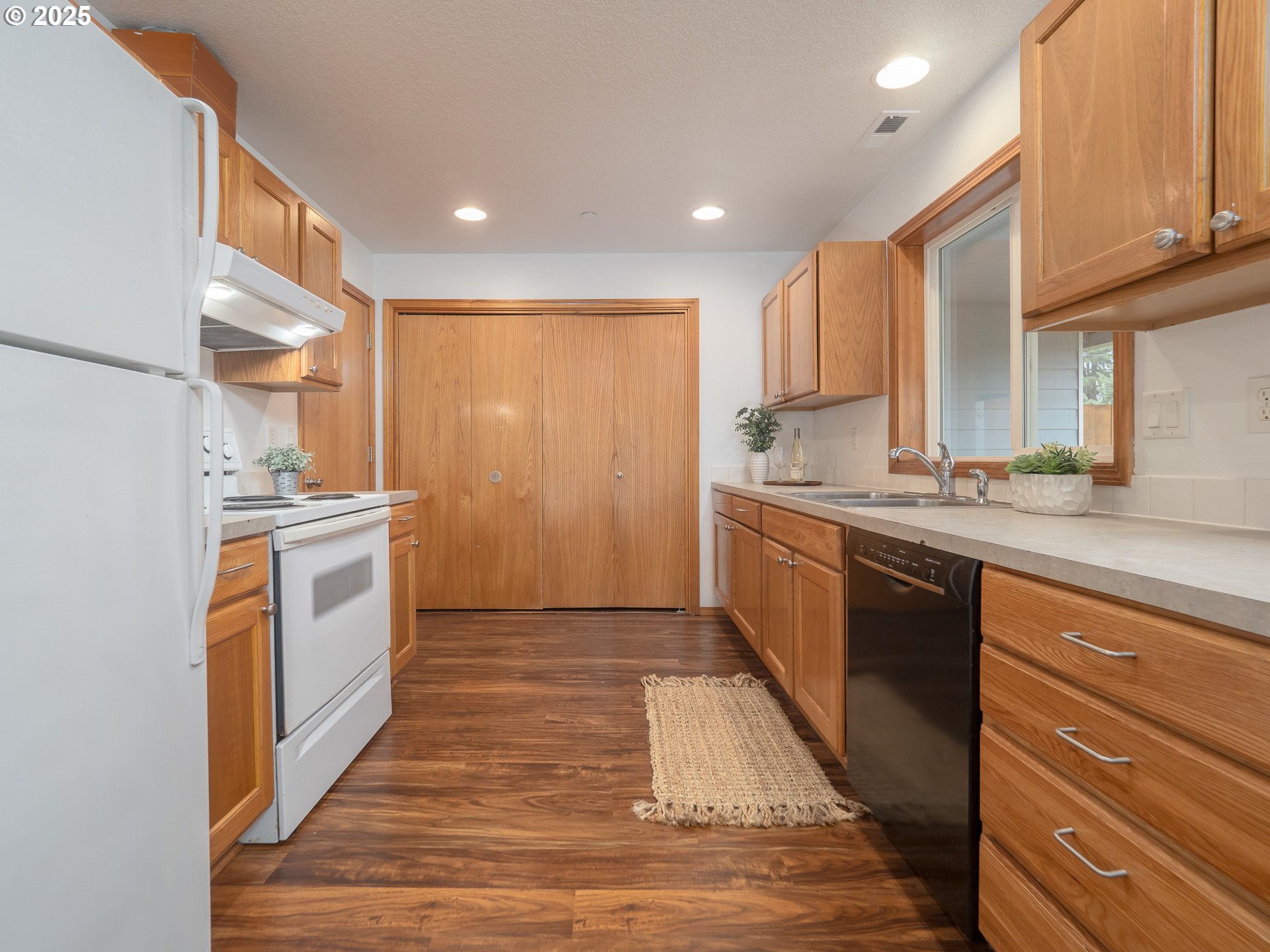 402 East Washington Street Carlton, OR 97111 - Photo 12 of 36 a kitchen with a sink stove cabinets and wooden floor