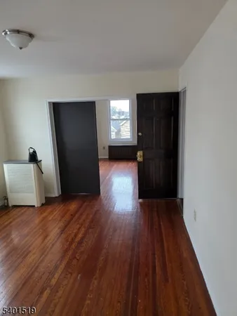 a view of a room with wooden floor and cabinet