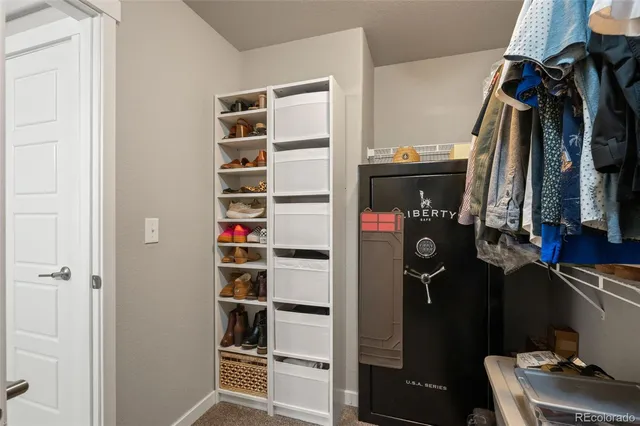 a view of walk in closet with clothes and shoes