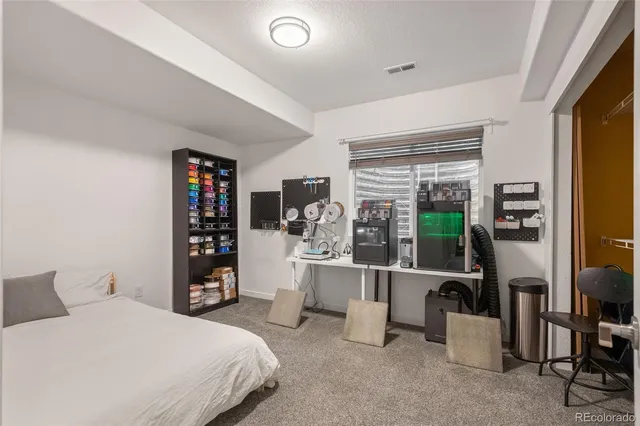 a bedroom with a bed a large window and book shelf