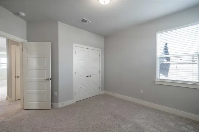 an empty room with windows and closet