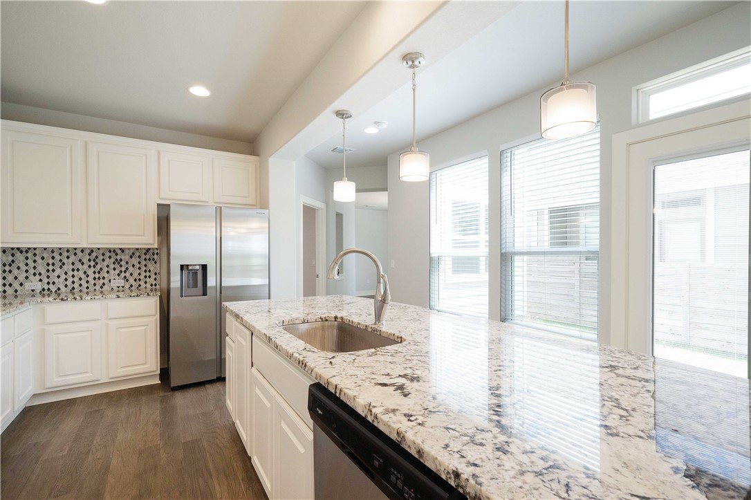 9124 Cattle Baron Path Austin, TX 78747 - Photo 7 of 36 a kitchen with stainless steel appliances granite countertop a sink a stove and a refrigerator