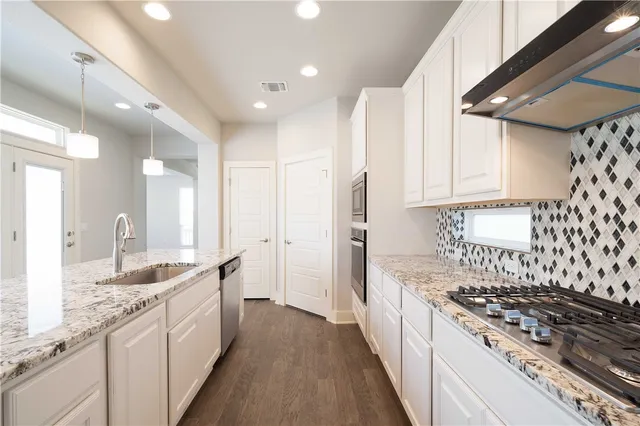 a large kitchen with kitchen island a sink stainless steel appliances and cabinets
