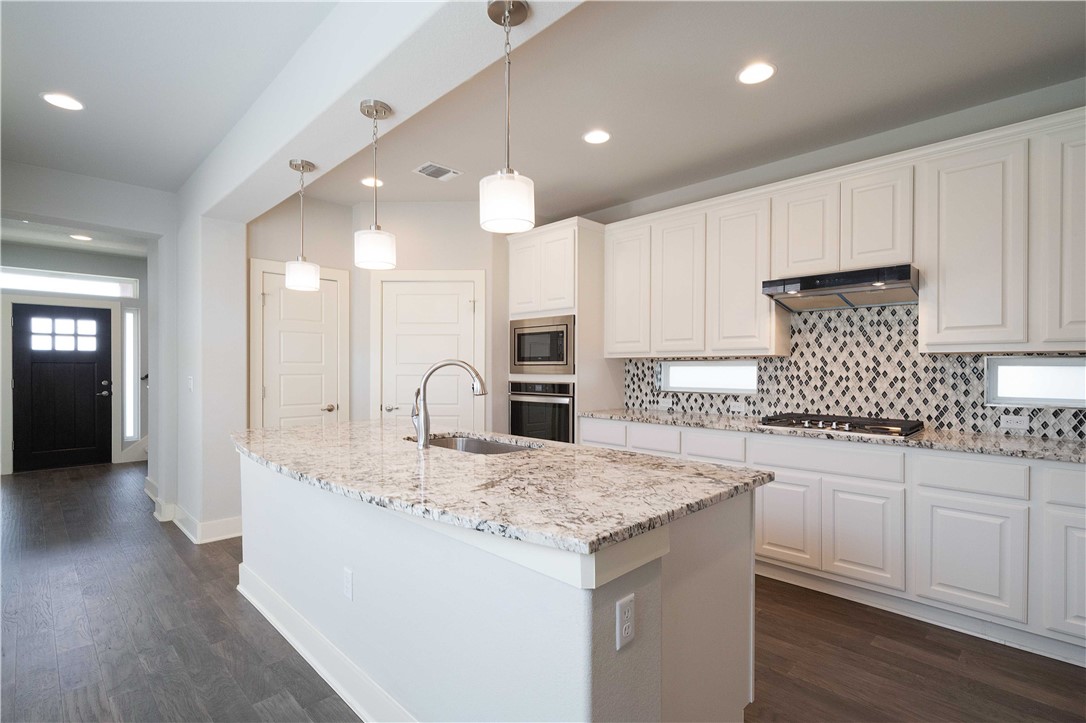 9124 Cattle Baron Path Austin, TX 78747 - Photo 9 of 36 a kitchen with center island and stainless steel appliances