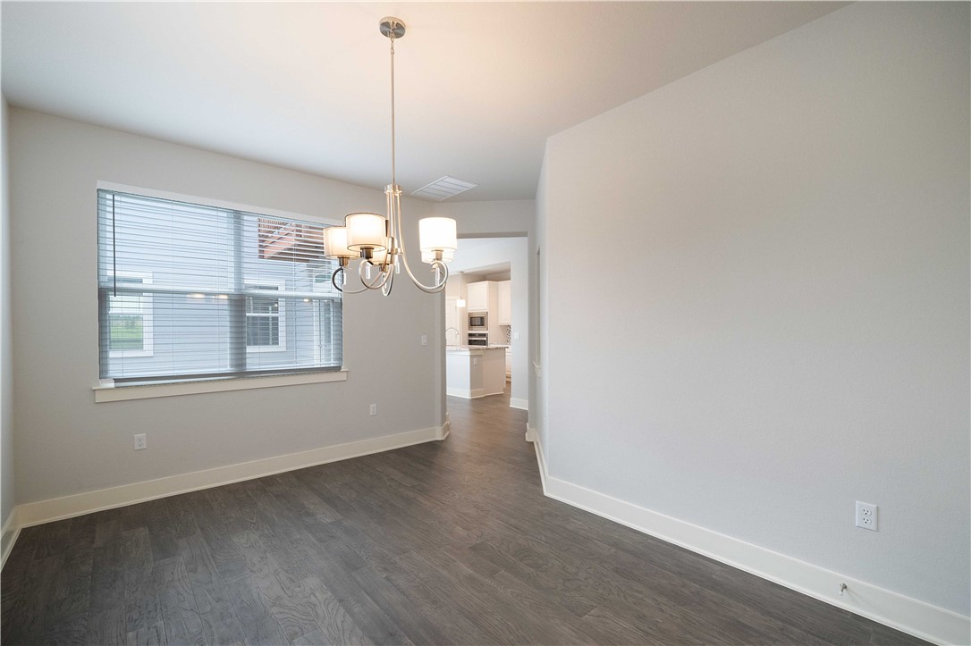 9124 Cattle Baron Path Austin, TX 78747 - Photo 10 of 36 a view of a room with wooden floor chandelier and windows