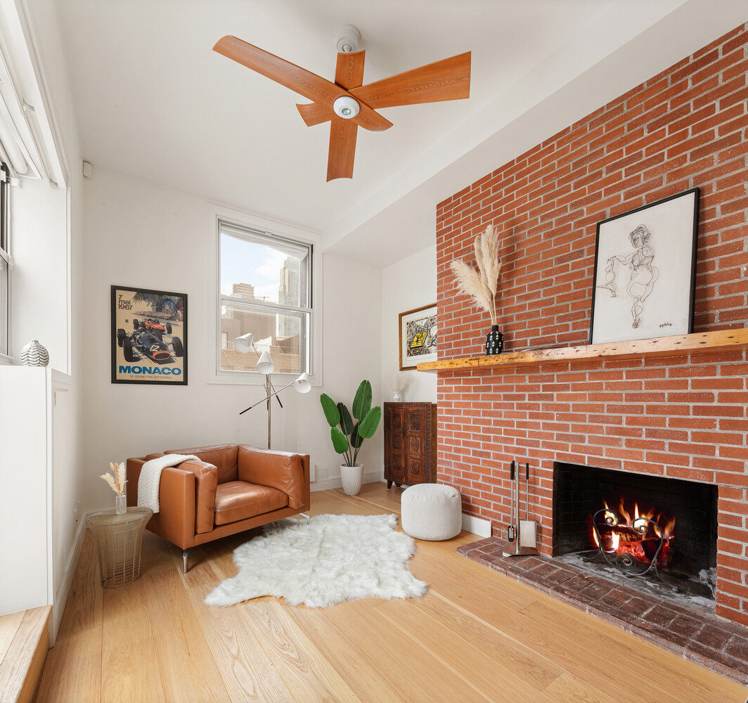 521 West 47th Street, Unit PHD Manhattan, NY 10036 - Photo 10 of 14 a living room with furniture and a fireplace