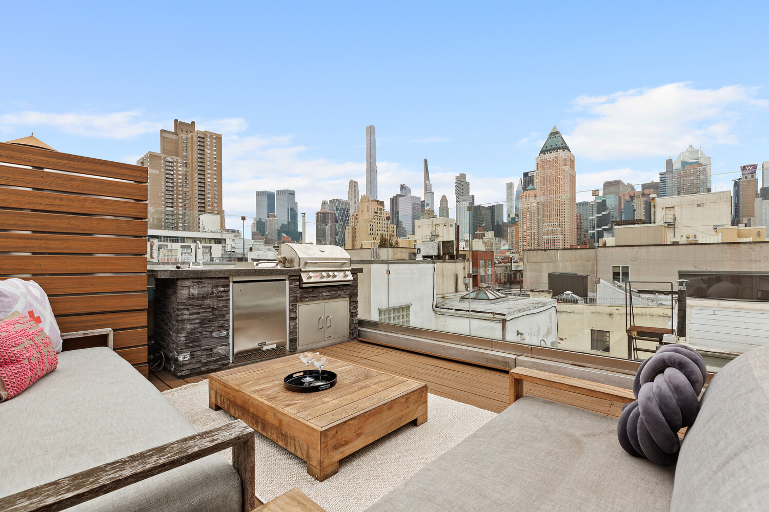 521 West 47th Street, Unit PHD Manhattan, NY 10036 - Photo 12 of 14 a roof deck with couch and a fireplace