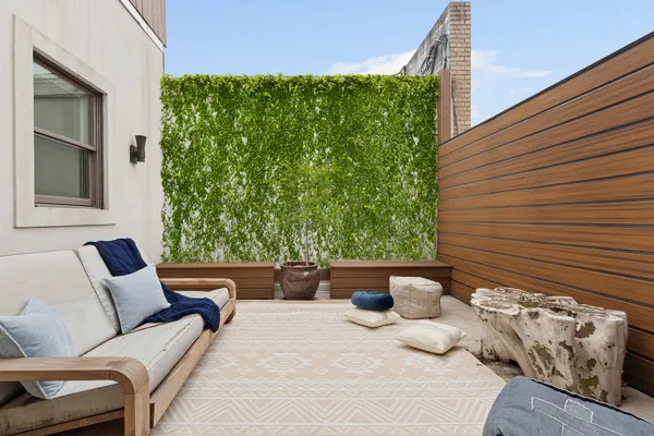 a roof deck with couch and a fireplace