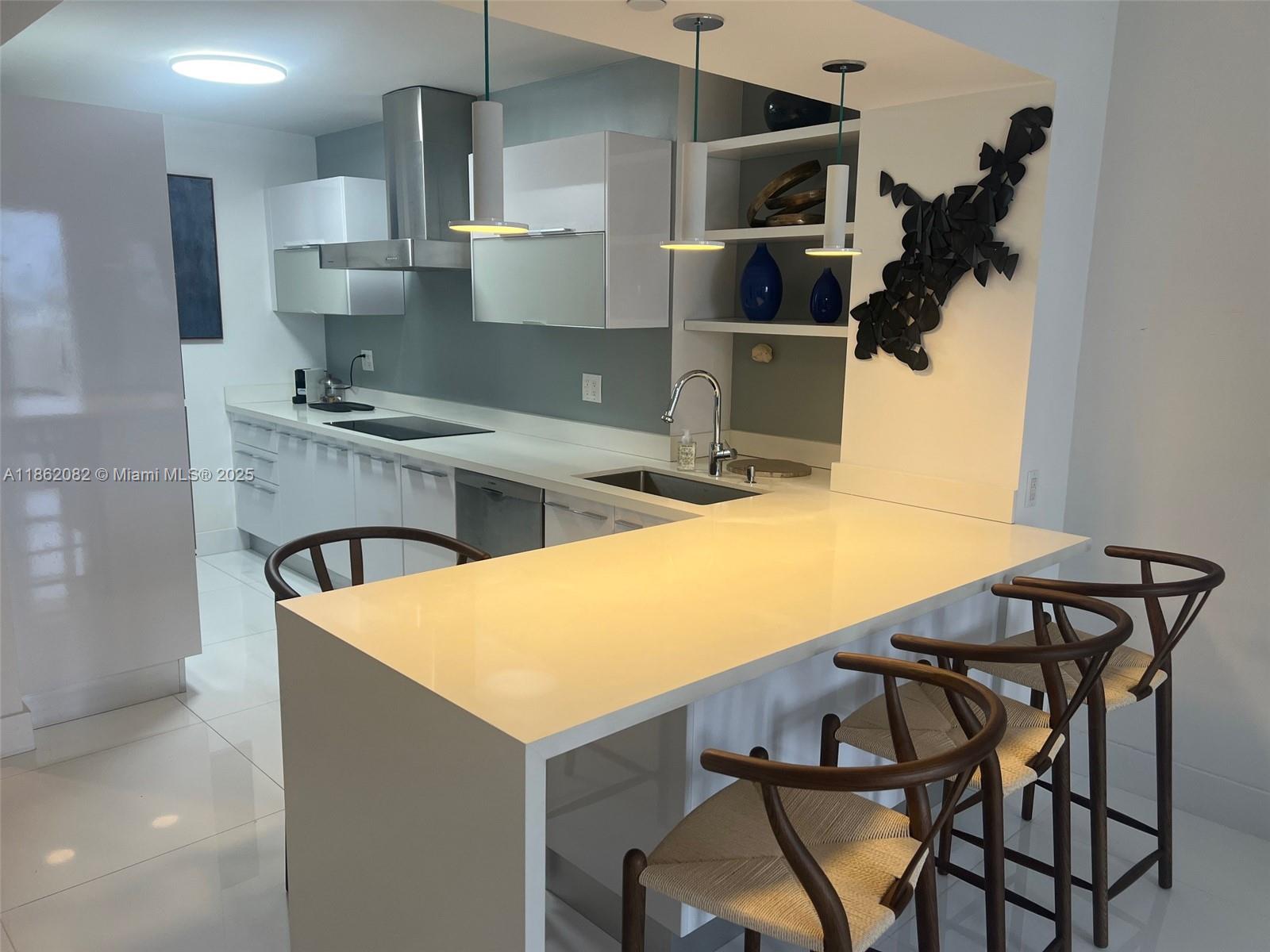 100 Lincoln Road, Unit 1022 Miami Beach, FL 33139 - Photo 11 of 63 a kitchen with a table chairs sink and stove