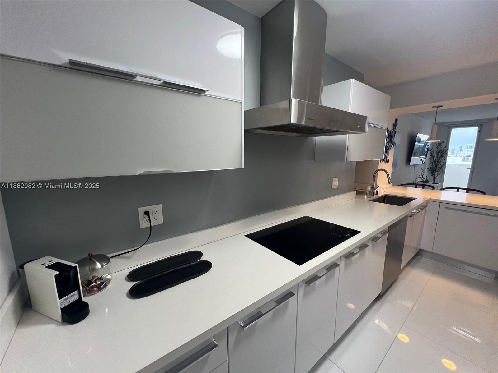 100 Lincoln Road, Unit 1022 Miami Beach, FL 33139 - Photo 16 of 63 a kitchen with a sink a stove and cabinets
