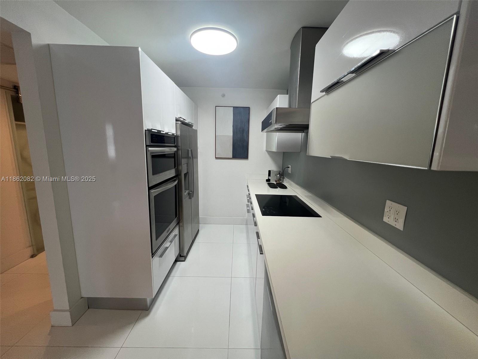 100 Lincoln Road, Unit 1022 Miami Beach, FL 33139 - Photo 17 of 63 a kitchen with a refrigerator and a sink