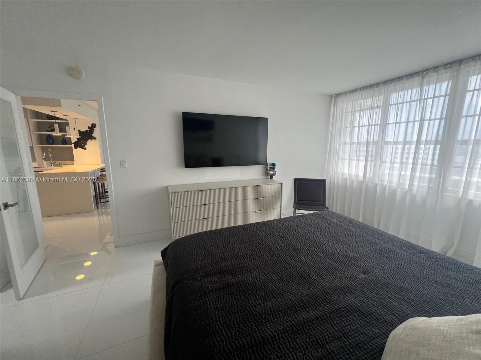 100 Lincoln Road, Unit 1022 Miami Beach, FL 33139 - Photo 27 of 63 a bedroom with a bed and a flat screen tv