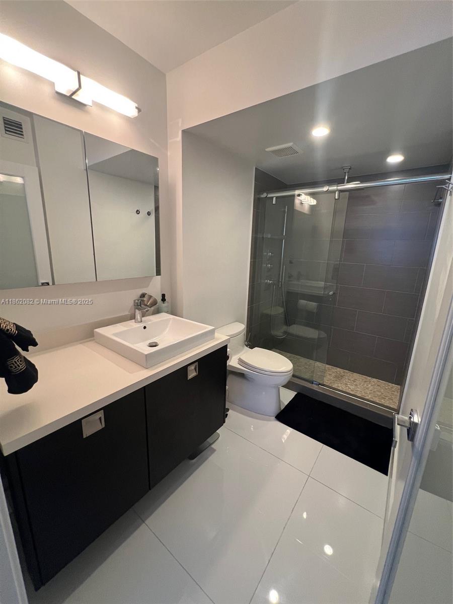 100 Lincoln Road, Unit 1022 Miami Beach, FL 33139 - Photo 36 of 63 a bathroom with a sink a toilet a mirror and shower