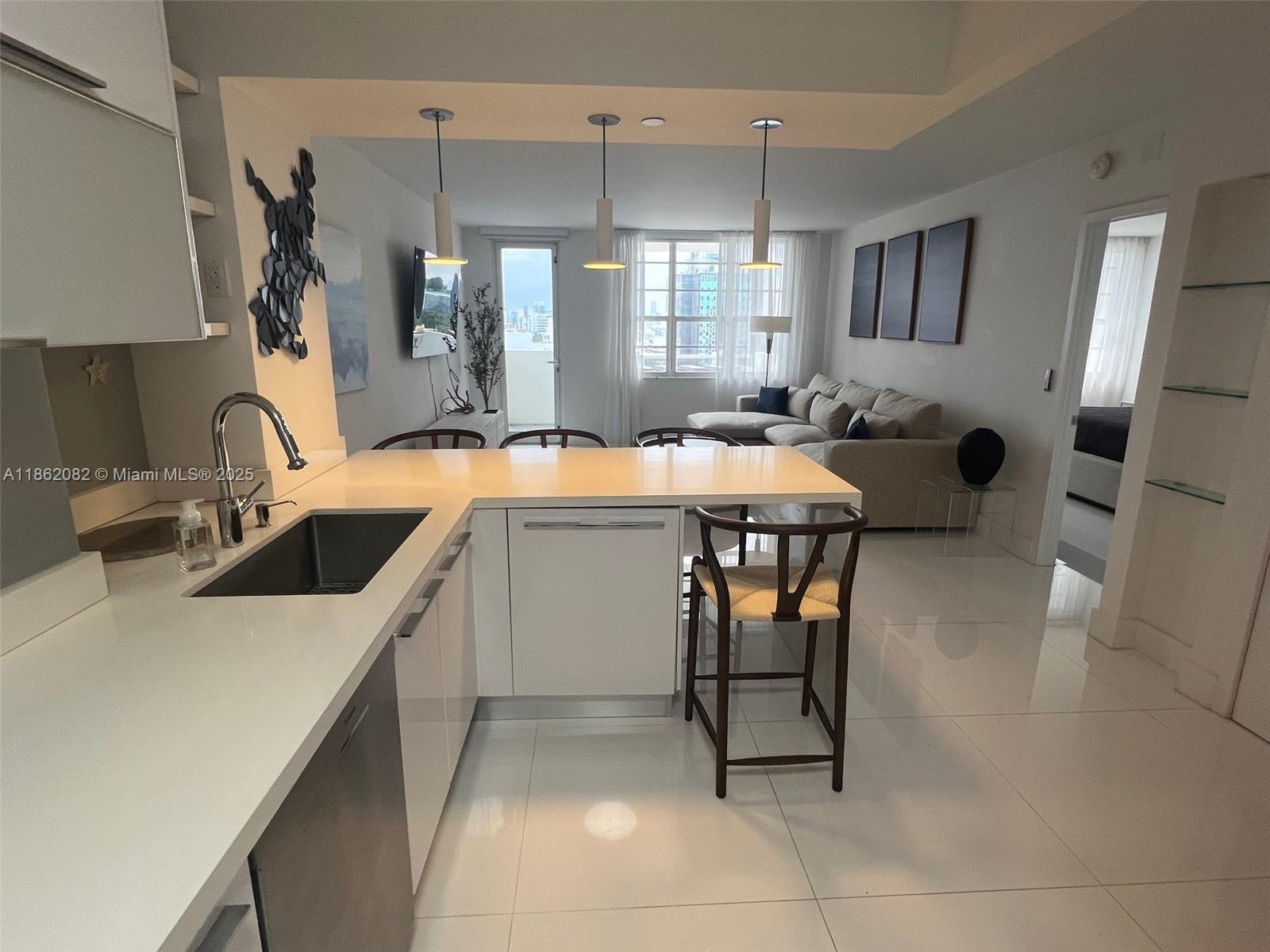 100 Lincoln Road, Unit 1022 Miami Beach, FL 33139 - Photo 9 of 63 a kitchen that has a sink a table and chairs in it