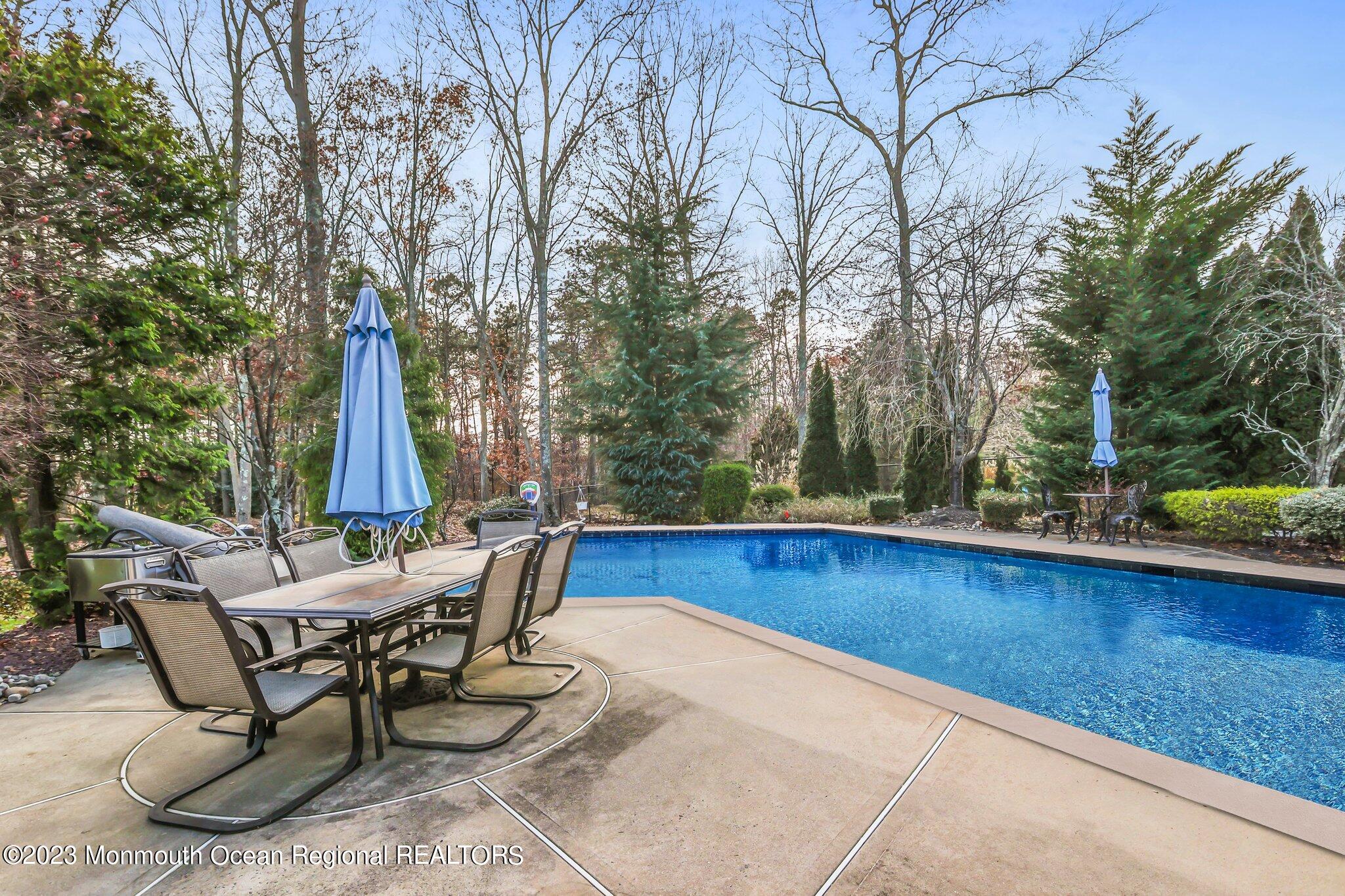 20 Round Hill Road Jackson, NJ 08527 - Photo 39 of 50 a view of a swimming pool with chair and table under an umbrella