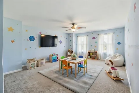 a living room with furniture a flat screen tv and a large window