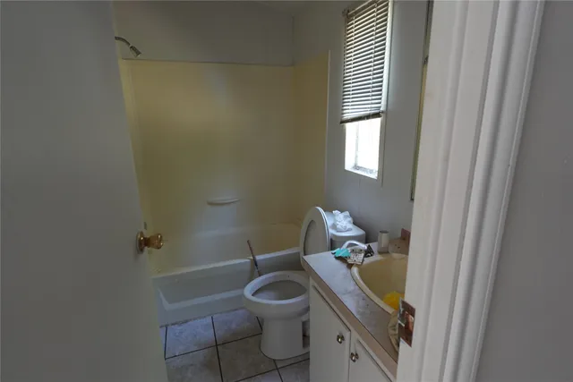 a bathroom with a granite countertop toilet a sink and a mirror