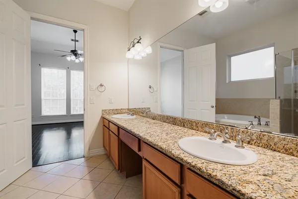 a view of a wooden chairs and table in the patio next to a yard