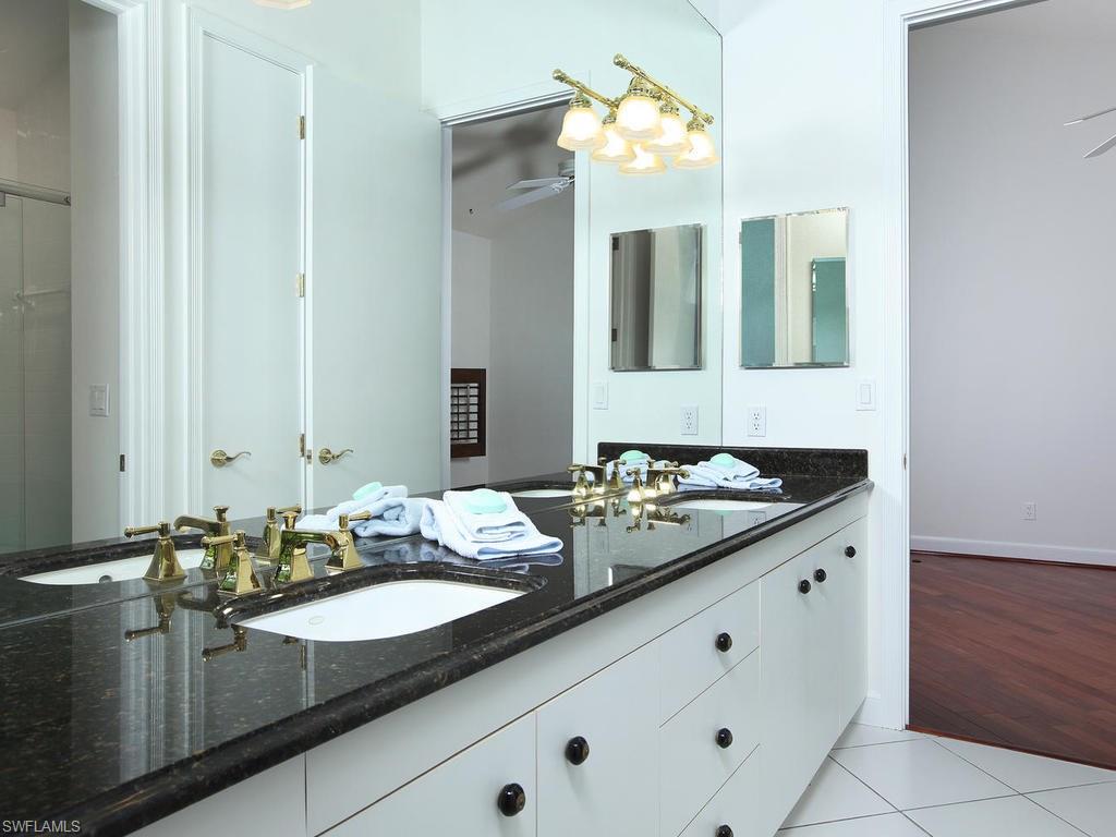 720 Turkey Oak Lane Naples, FL 34108 - Photo 12 of 17 a bathroom with a sink and a mirror