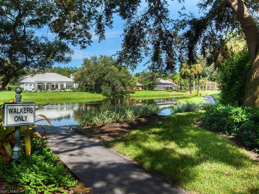 720 Turkey Oak Lane Naples, FL 34108 - Photo 16 of 17 a view of a garden with a table and chairs under an umbrella