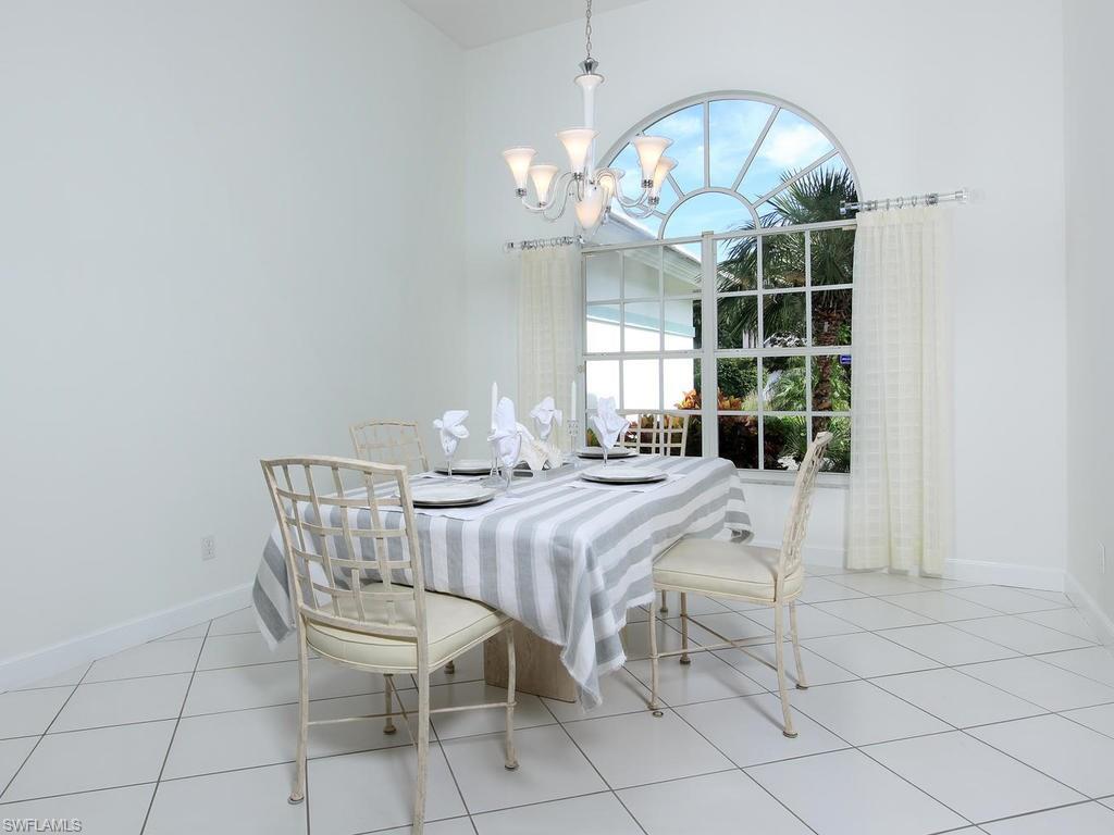 720 Turkey Oak Lane Naples, FL 34108 - Photo 6 of 17 a view of a dining room with furniture and chandelier